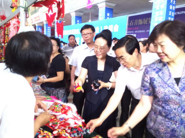 图为参加首届京津冀残疾人就业创业洽谈会的领导参观北京巧娘手工艺品展示