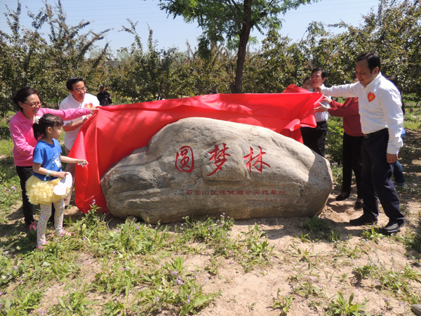图为中残联、北京市和石景山区与会领导为圆梦林揭牌。