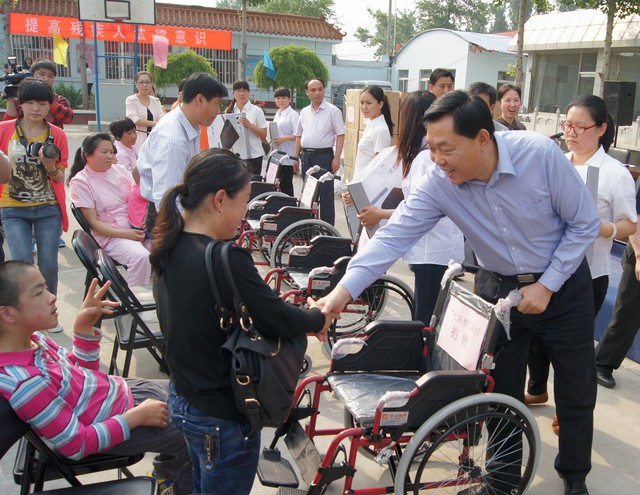 副区长刘胜国为参加儿童发放轮椅