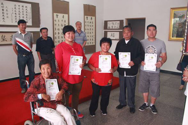 图为区残联领导在展览室为获奖残疾朋友颁发获奖证书