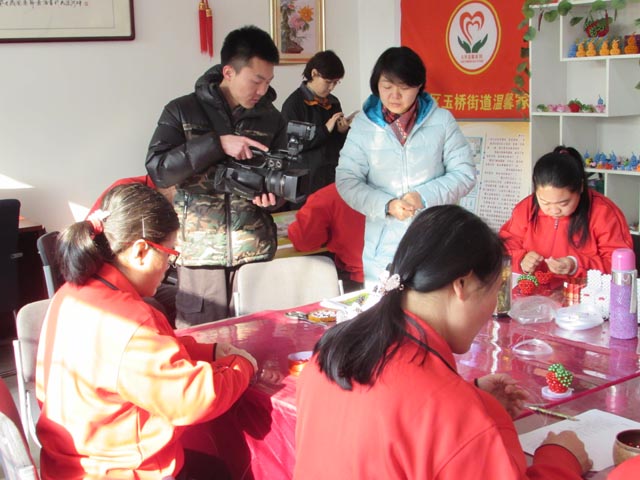 北京电视台记者在拍摄温馨家园学员手工项目康复活动