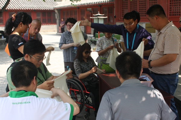 北京文博交流馆馆工作人员指导残疾人朋友制作扎染
