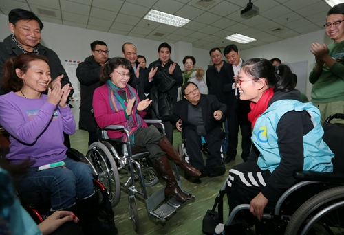 图为海迪主席调研脊髓损伤学员康复训练情况，这是学员在进行轮椅使用训练