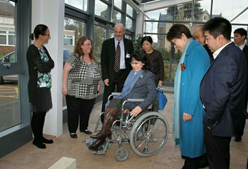 图为张海迪主席考察爱丁堡爱斯利医院康复工作时体验轮椅训练