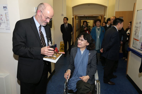 图为海迪主席向医院负责人赠送亲手设计的轮椅模型及书籍