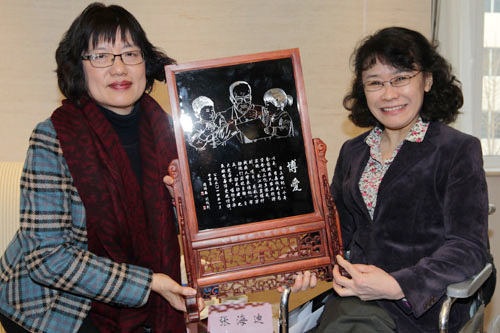 图为张海迪主席和罗慧芳女士展示长江新里程项目二期残疾人受益者送给李嘉诚先生的美术作品