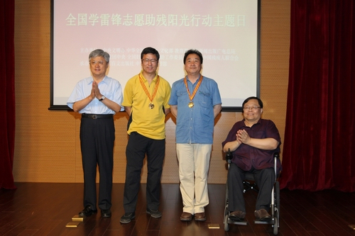 图为与会领导向爱心大使姜昆、白岩松颁发“中华志愿助残阳光大使奖章”