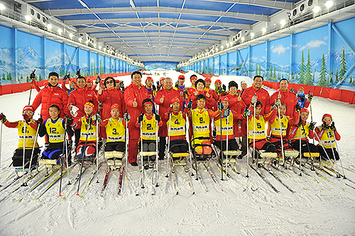 图为王梅梅一行与集训的冰雪项目残疾人运动员合影