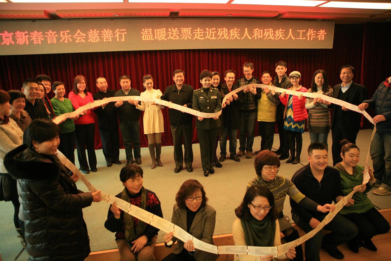 图为接受门票的残疾人工作者代表与“第九届北京新春音乐会”的艺术家合影