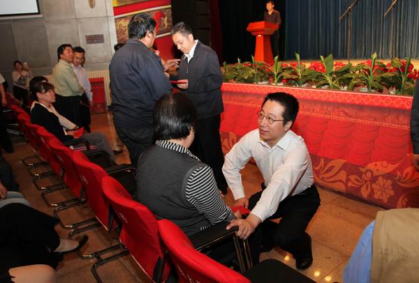 图为市残联副理事长唐海蛟区委组织部长霍连明将救助金发放到残疾人手中
