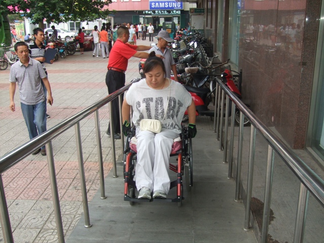 图为  肢体残疾人代表体验无障碍坡道