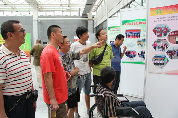 图片为：残疾人朋友参观北京市基层残疾人群众体育图片展