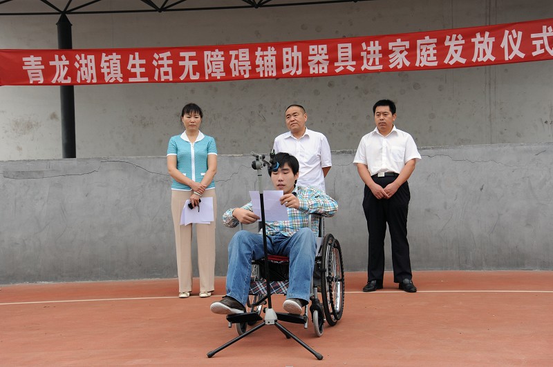 图为：发放仪式现场，残疾人代表发言