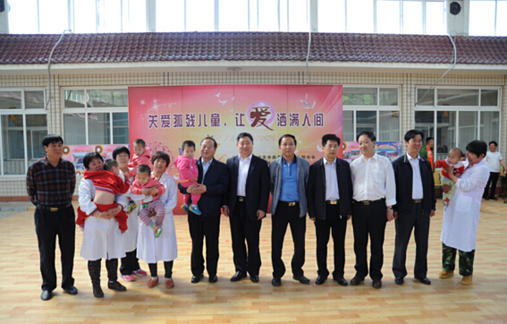 图为区政府副区长刘长永（右六）与相关部门领导和孤残儿童合影
