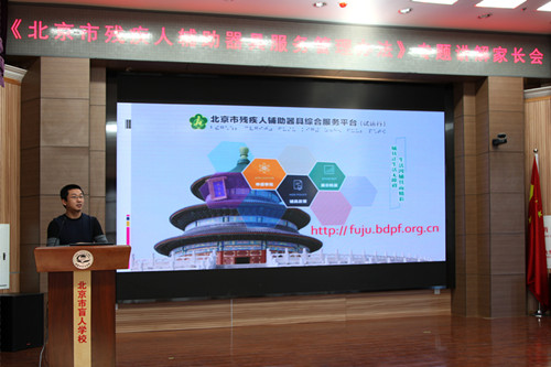 图为工作人员解读 “辅具政策”，演示平台操作流程