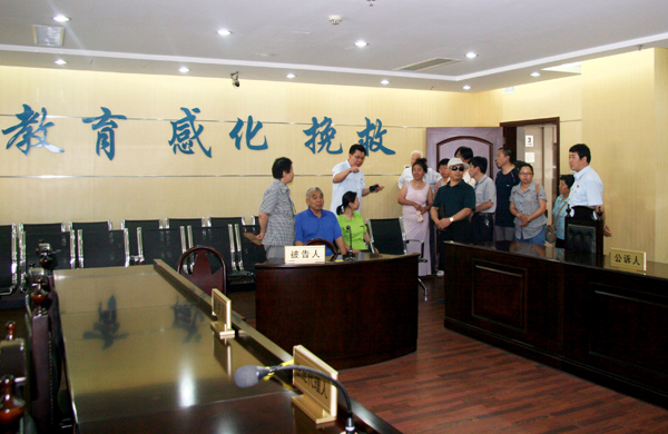 图为残疾人参观法院服务设施
