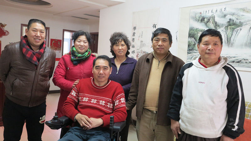 图为管庄街道工作人员与残疾人合影