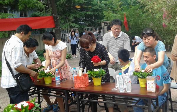 图为残疾儿童在指导下制作插花作品