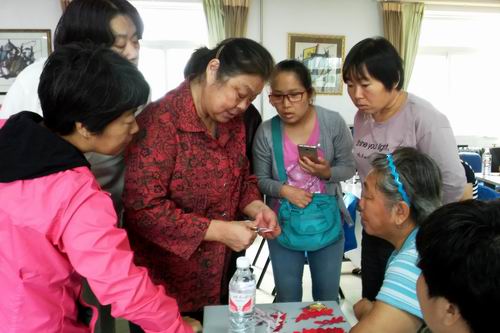 图为培训老师手把手传授剪纸技能
