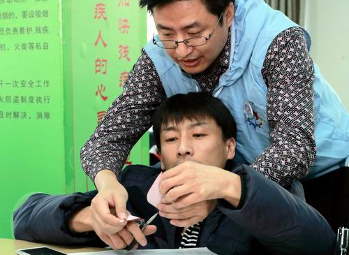 图为老师手把手传授剪纸技能