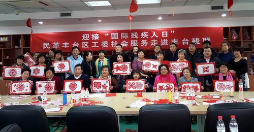 图为大家手举剪纸作品合影留念