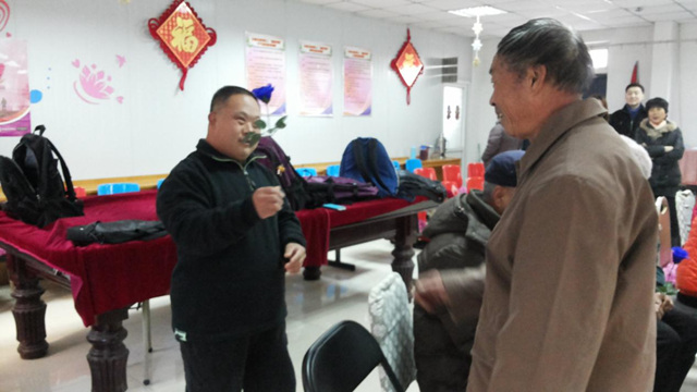 图为：服务对象送绢花给家长