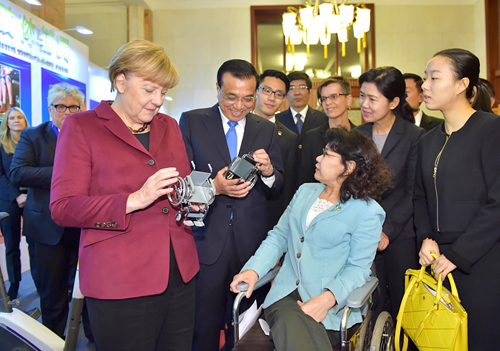中国残疾人联合会主席张海迪向两国总理赠送了自己亲手设计的轮椅模型
