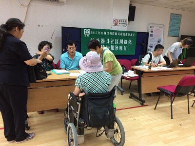 图为现场对残疾人朋友提供政策咨询和上网指导